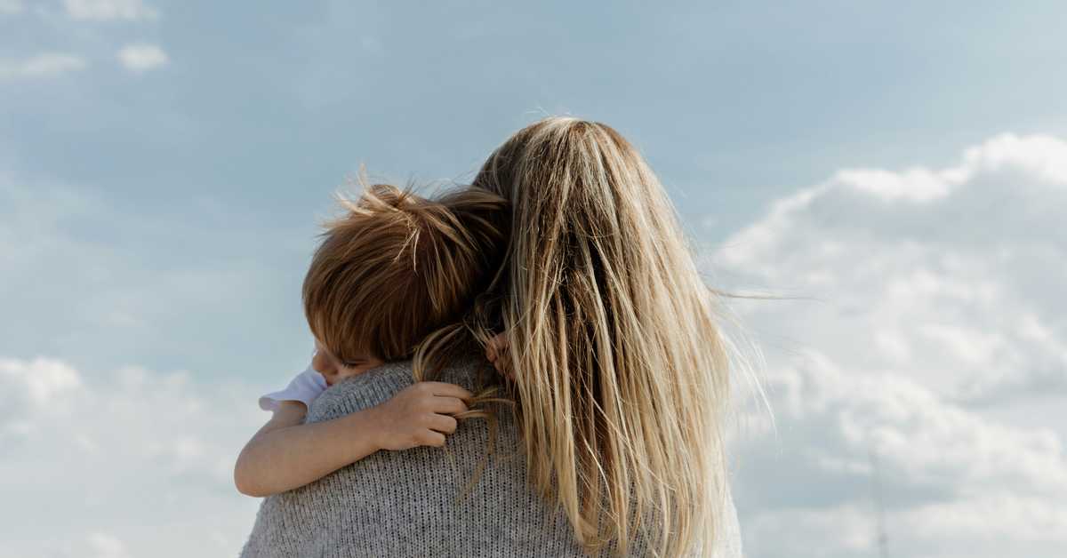 Femme de dos avec un enfant dans les bras