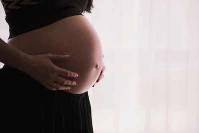 Femme enceinte qui pose ses mains sur son ventre