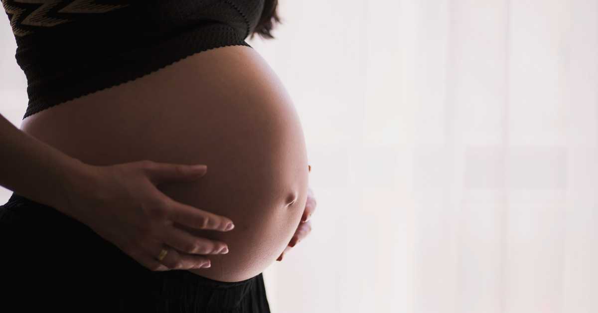 Femme enceinte qui pose ses mains sur son ventre